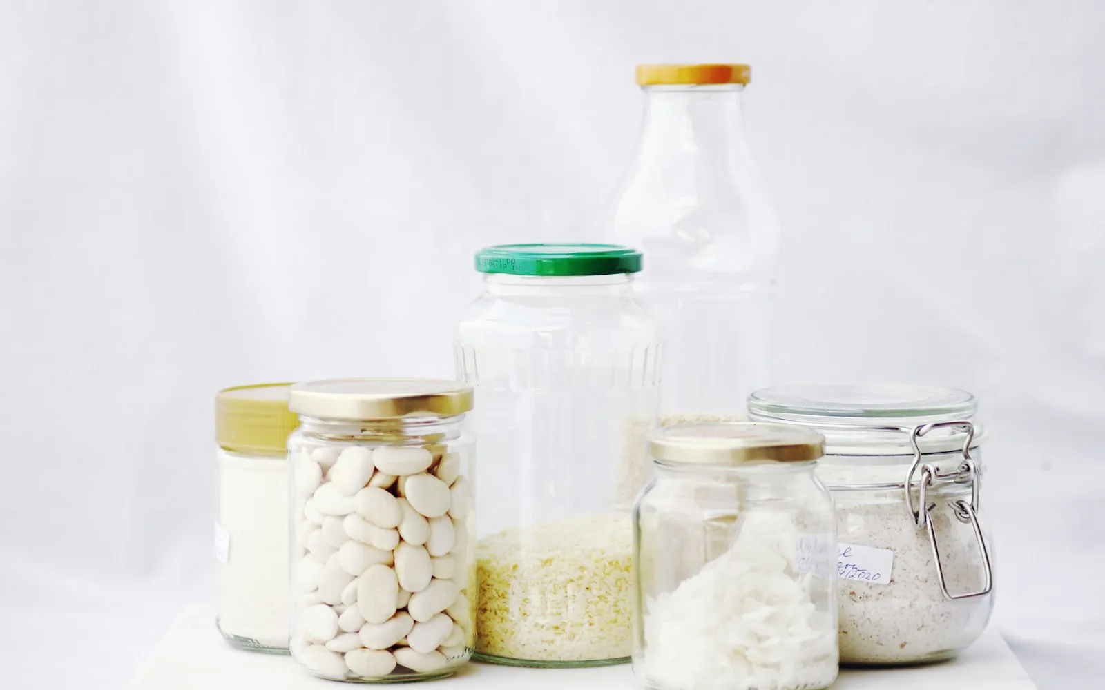 Glazen potten met bonen en rijst, met deksels van verschillende materialen