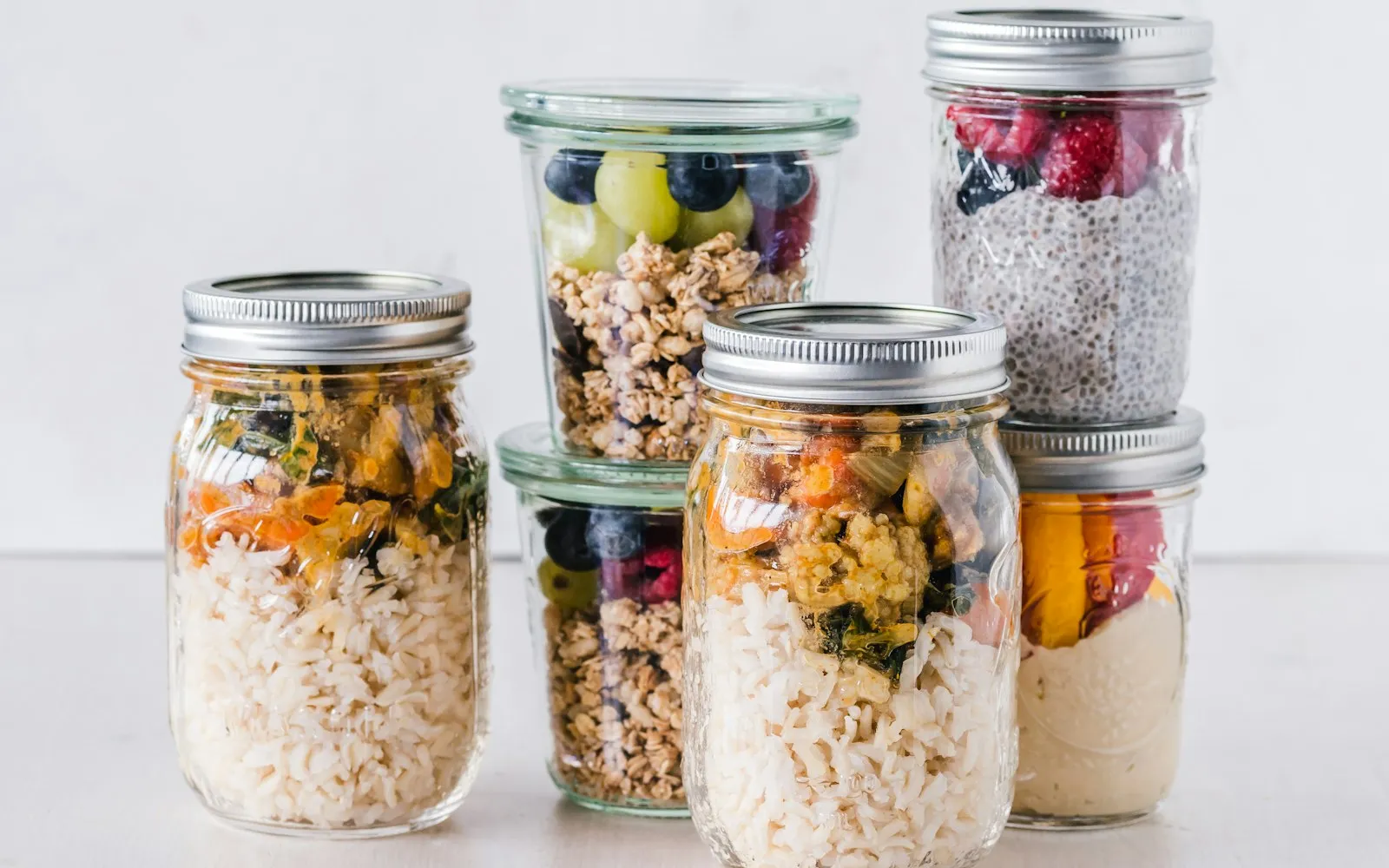 Glazen weckpotten met muesli, fruit en rijst, met metalen klemmen